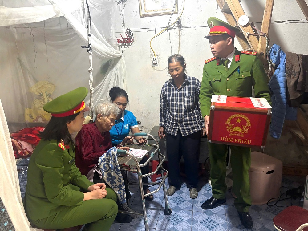 Công an xã Hợp Tiến cùng Tổ bầu cử số 12 mang hòm phiếu phụ đến nhà Mẹ Việt Nam Anh hùng Phan Thị Cẳm